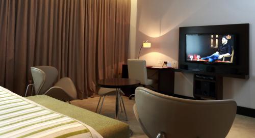 a hotel room with a television and a table and chairs at Hotel y Casino Del Río - General Roca in General Roca