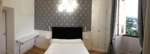 a white room with a bed and a window at A Spelunca in Speloncato