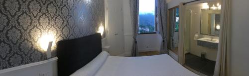 Schlafzimmer mit einem Bett, einem Waschbecken und einem Spiegel in der Unterkunft A Spelunca in Speloncato