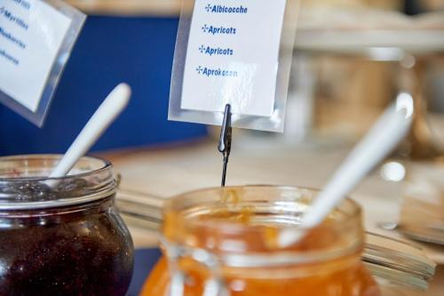 two mason jars of honey with a sign on them at Hotel Croce Di Malta in Imperia