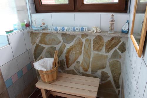 ein Badezimmer mit einer Bank und einer Felswand in der Unterkunft Ferienwohnung Rabenstein in Dornum