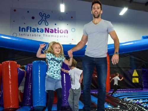 a man and two children playing in an indoor trampoline park at Media City Salford Quays in Manchester