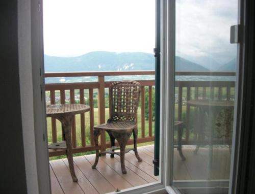 a balcony with a chair and a table and a window at Agri-park Casa Miramonte in Ronzone