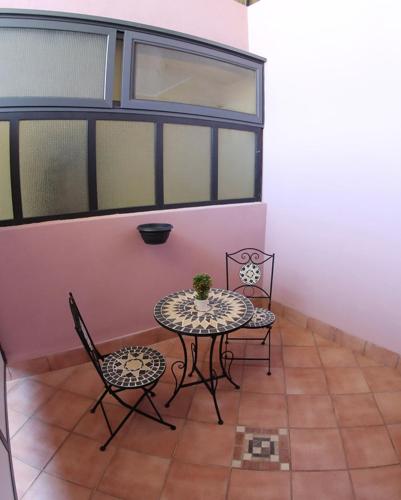 a small table and chairs in a room with a window at Policlinico Happy Home in Messina