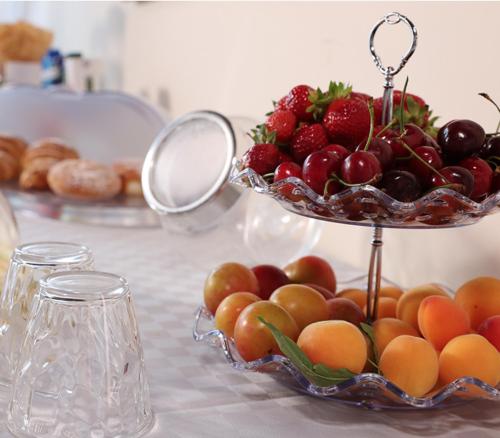 a bowl of fruit on a table with a plate of fruit at Policlinico Happy Home in Messina