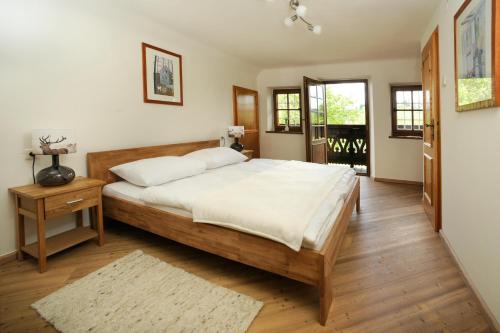a bedroom with a large wooden bed with white sheets at Stupperhof in Kitzeck im Sausal