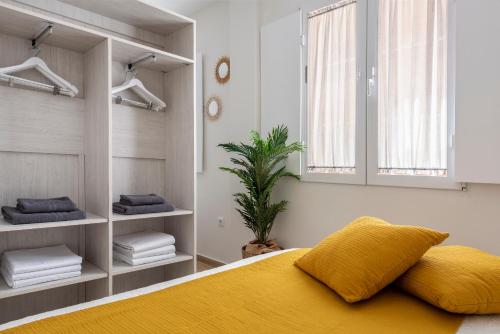 セビリアにあるAzafran Suitesのベッドルーム1室(黄色いベッド1台、窓付)