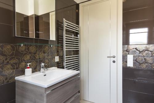 a bathroom with a sink and a mirror at Roggia Apartments by Quokka 360 - central flats with parking space in Lugano