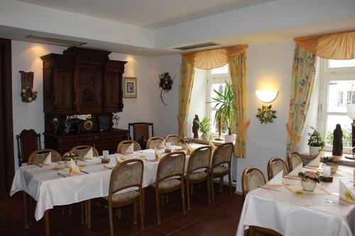 jadalnia ze stołami i krzesłami z białymi obrusami w obiekcie Hotel Zum Stern w mieście Bad Neuenahr-Ahrweiler