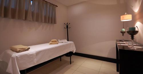 a hospital room with a bed and a table at Hotel y Casino Del Río - General Roca in General Roca