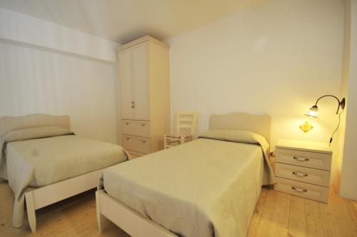 a bedroom with two beds and a dresser at Morfeo Charming Rooms & Relax in Avola