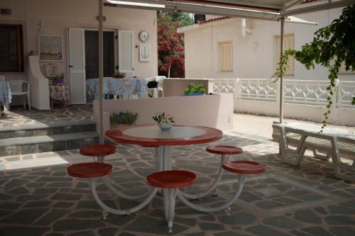a table and four stools on a patio at The Twins in Glífa