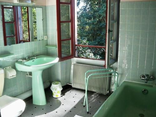 łazienka z umywalką, toaletą i wanną w obiekcie Chambres d'Hôtes Closerie du Guilhat w mieście Salies-de-Béarn