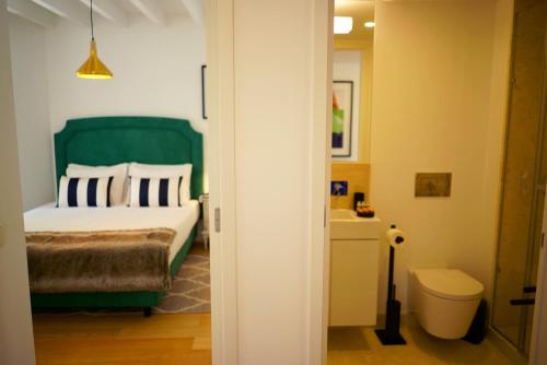 a bedroom with a green bed and a bathroom at Casas da Baixa - Vila Intendente in Lisbon