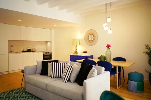 a living room with a couch and a table and a kitchen at Casas da Baixa - Vila Intendente in Lisbon