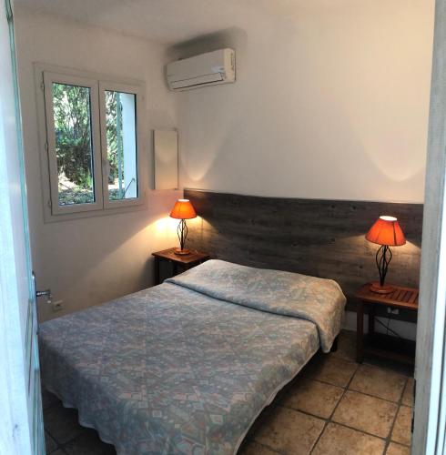 - une chambre avec un lit et deux lampes sur les tables dans l'établissement Residence ISULA DI I CORSI, à Zonza