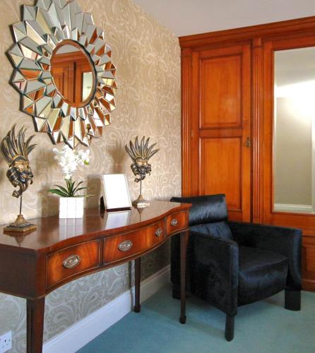a room with a desk with a chair and a mirror at The Mainstay Luxury Boutique Rooms with Private Parking in Whitby