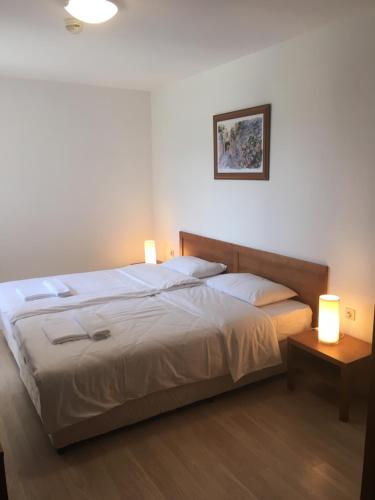- une chambre avec un lit et 2 lampes dans l'établissement St. John Hill Apartment, Bansko, à Bansko