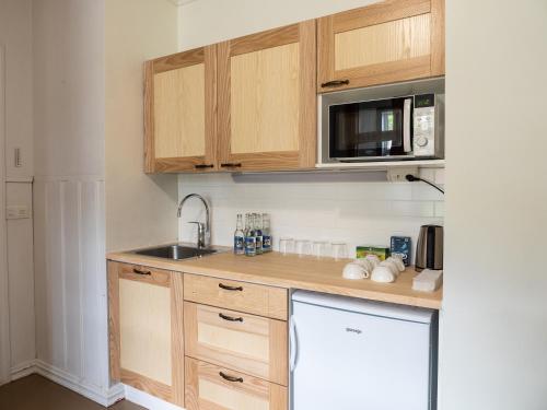 a small kitchen with wooden cabinets and a sink at Haapala Brewery restaurant and accommodation in Vuokatti