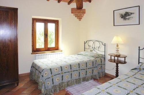 
a bedroom with two beds and a lamp at Podere Il Gioiello in San Gimignano
