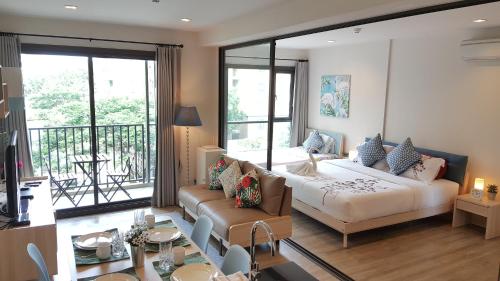 um quarto com uma cama e uma sala de estar em Rain Cha-am by Obbset em Cha Am
