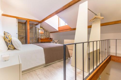 ein Schlafzimmer mit einem großen Bett und einem Balkon in der Unterkunft Gaia Woodstone Hideout in Vila Nova de Gaia