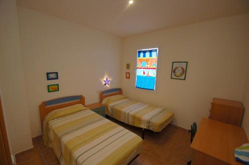 a hotel room with two beds and a window at Daró 3D 37 Airco Mas Pinell in Torroella de Montgrí
