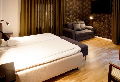 a hotel room with a bed and a chair at Södra Hotellet in Norrköping