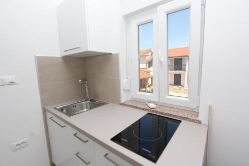 a small kitchen with a sink and a window at Apartment Mihaela in Rovinj