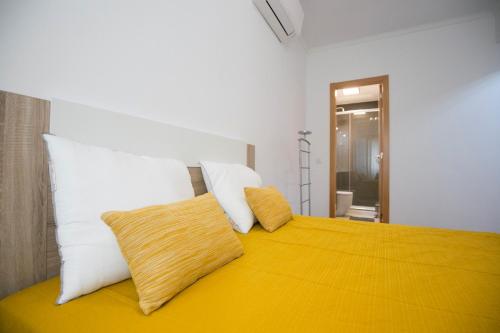 ein Schlafzimmer mit einem Bett mit zwei Kissen darauf in der Unterkunft Akicity Graca Silver in Lissabon