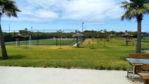 a park with a playground with a swing set at Savannah Beach D11 in Sidi Rahal