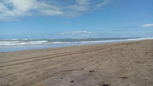 a beach with footprints in the sand and the ocean at Savannah Beach D11 in Sidi Rahal