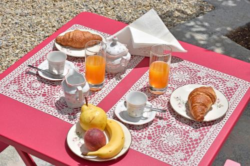 a pink table with plates of food and fruit on it at Castelli in aria in Finale Ligure