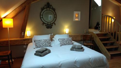 a bedroom with a large bed with towels on it at La Blinerie in Sambin