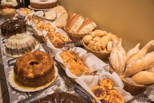 a table topped with lots of different types of pastries at Pousada Hospedaria da Villa in Tiradentes