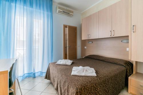 Un pat sau paturi într-o cameră la Hotel Rubens