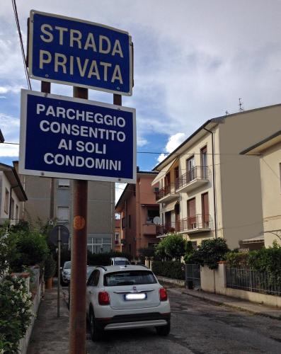 a blue street sign on a pole with a car at Apt luminoso, spazioso con Aria condiz e bici in Viareggio