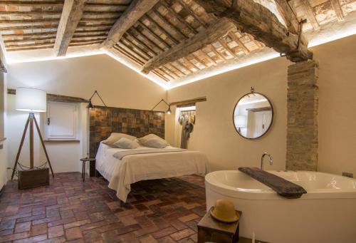 カスティリオーン・フィオレンティーノにあるTuttomio Home&Breakfast Suite with whirlpoolのベッドルーム(ベッド1台、バスタブ付)