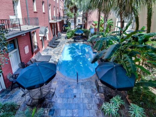 a swimming pool with umbrellas and chairs and a pool at Chateau Orleans in New Orleans