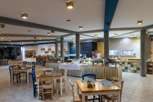 a restaurant with wooden tables and chairs and a cafeteria at Lindian Jewel Hotel and Villas in Lindos