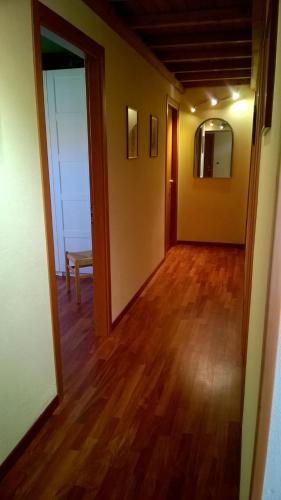 an empty room with a hallway with a wooden floor at La Stanza Verde in Rossiglione