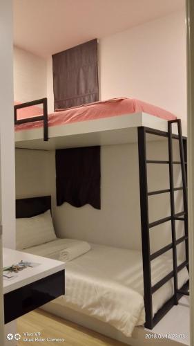 two bunk beds in a room with a desk at ExcluSuites Malacca @ The Wave Residence in Melaka