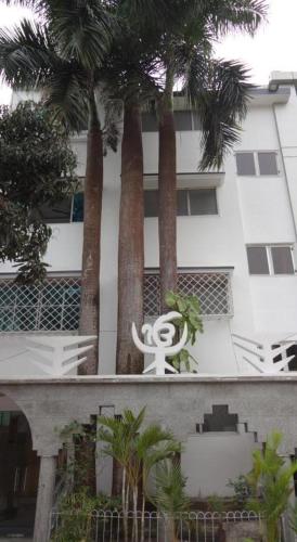 a white statue in front of a building with palm trees at Sher-E-Punjab in Kolkata
