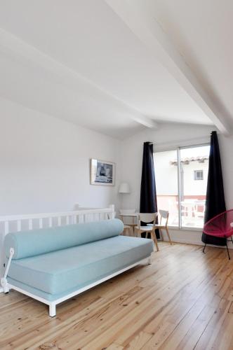 a white bedroom with a blue bed and a table at Temporesidence Chateauneuf in Bayonne