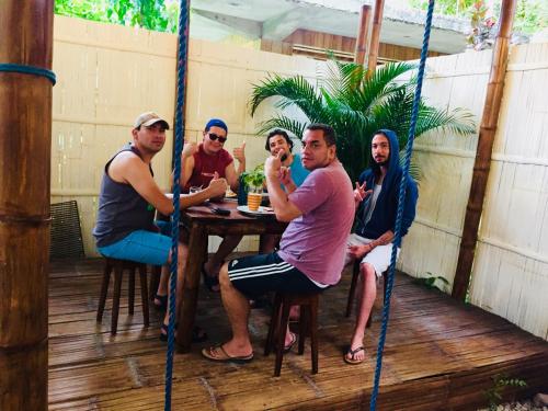 a group of men sitting at a table on a porch at Sapa Inka in Montañita