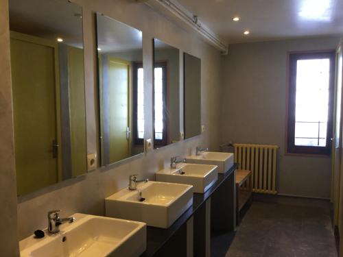 a bathroom with three sinks and a large mirror at Xalet-Refugi U.E.C. in La Molina