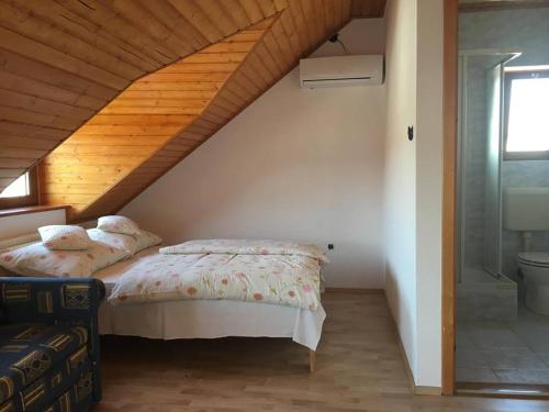 1 dormitorio con cama y techo de madera en Csók Apartmanház, en Balatonfüred