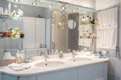 a bathroom with two sinks and a large mirror at Luxurious apt in the Athenian Riviera in Athens