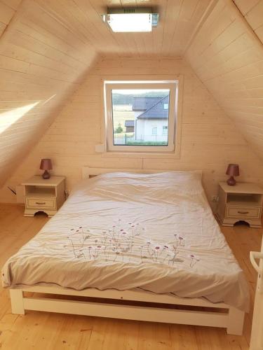 a bed in a room with two night stands and a window at Domek Aneczka Dębina in Dębina