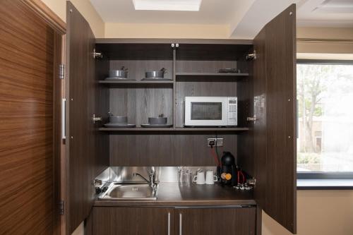a kitchen with a sink and a microwave at Grainger Apartments in Newcastle upon Tyne
